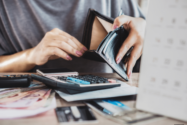A lady looking into an empty wallet calculating her expenses