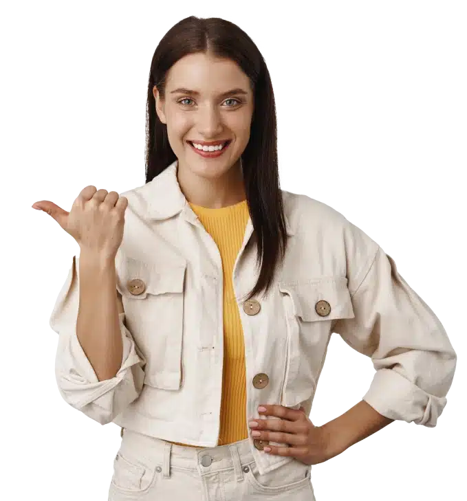 A confident, smiling woman with straight brown hair wearing a beige cropped jacket over a yellow top. She is pointing to her left with her thumb, suggesting direction or recommendation, and standing against a transparent background.