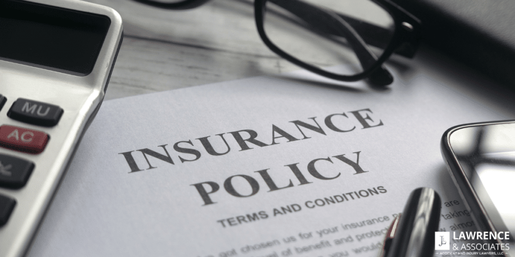 Insurance policy paperwork on desk with other items on it