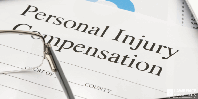 Closeup of paperwork with the words "personal injury compensation" on it with glasses on top of the paper
