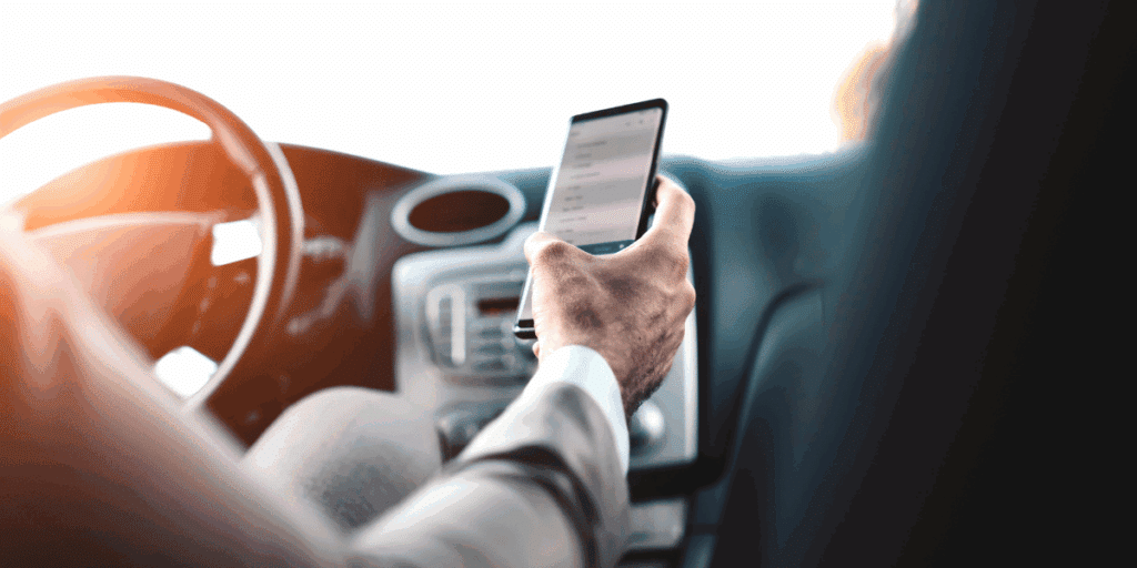 Person holding cell phone and scrolling while driving