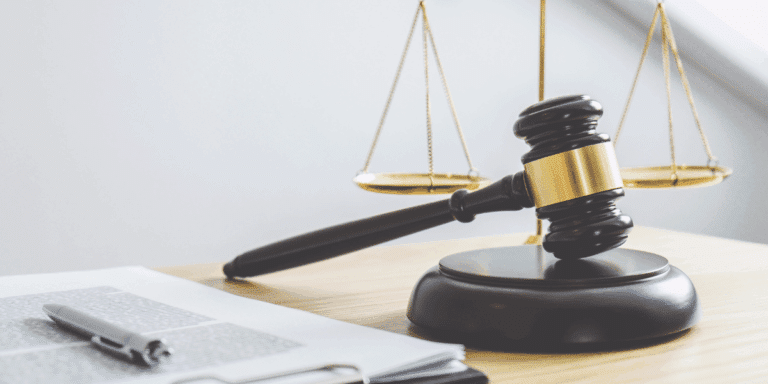 Close up of gavel with the scales of justice behind it