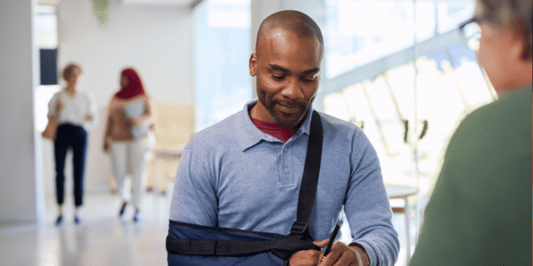 Man with injured arm in a sling talking to another person