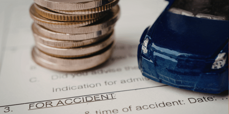 Close up of toy car next to a stack of coins on car paperwork