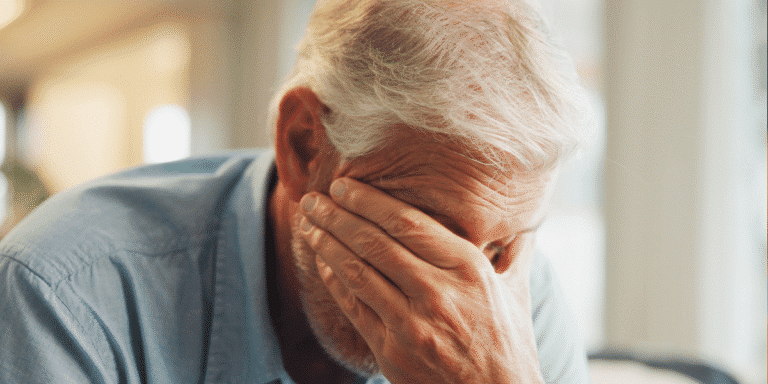 Close up of man covering his face with his hand